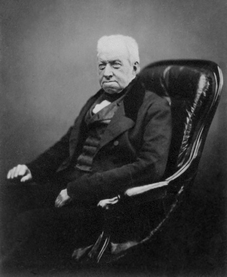 Retrato fotográfico de Robert Brown, idoso, sentado, de casaco escuro.